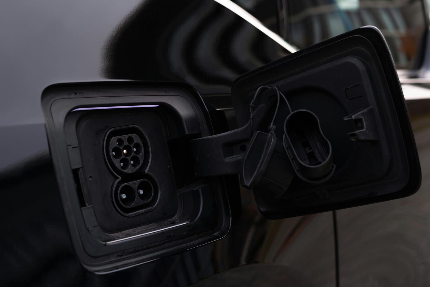 An EV charging port on a vehicle in a garage