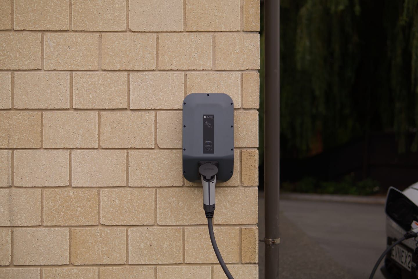 A hardwired Level 2 EV charger mounted on a garage wall