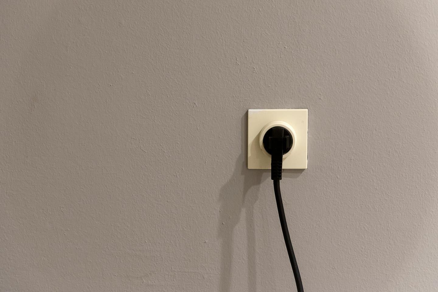 A NEMA 14-50 outlet with a portable EV charger plugged in